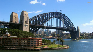 Bridge river city boat building - a city in the background and a boat free wallpaper