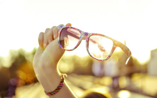 Woman holding glasses sunshine lens - a pair of glasses free wallpaper