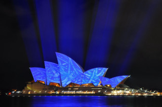 Large blue light building dark - the side of a building free wallpaper