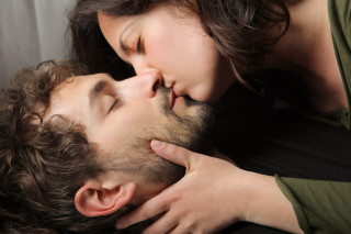 Woman kissing man eyes closed - a stock photo free wallpaper