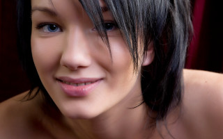 Woman black hair smile chest - a red curtain behind her free wallpaper