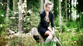Woman sitting rock forest background - a rock in a forest free wallpaper