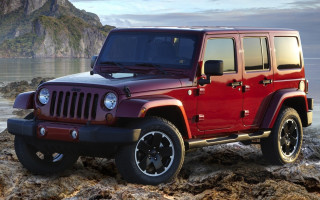 Red jeep rocky beach ocean 3 - a mountain in the background and a body of water free wallpaper