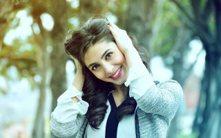 Smiling woman curly hair outdoors - holding free wallpaper