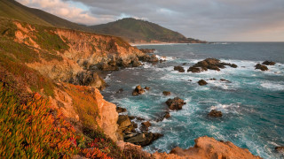 Rocky cliff ocean green hillside - a green hillside in the background free wallpaper