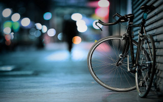 Bicycle wall city night blurry - against a wall free wallpaper