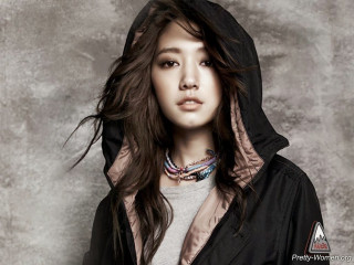Woman hoodie pose gray background 2 - a gray wall behind her free wallpaper
