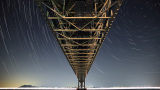Long exposure bridge stars mountain - a body of water below free wallpaper