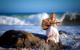 Woman sitting rock playing guitar - portrait photography free wallpaper