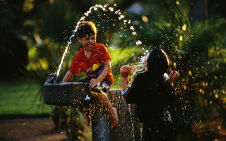 Boy girl playing fountain water - the park free wallpaper