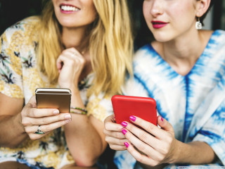 Women sitting cell phones together 2 - product photo free wallpaper