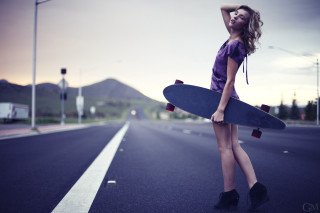 Woman holding skateboard side road - a skateboard free wallpaper