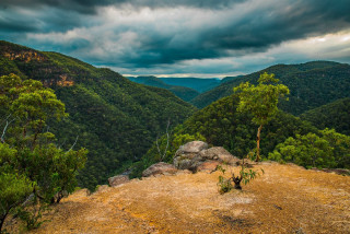 Valley trees mountains cloudy sky - a view of a valley free wallpaper