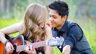 Man woman grass playing guitar 2 - a guitar free wallpaper