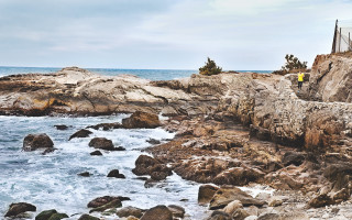 Man standing rocky cliff ocean - a surfboard free wallpaper