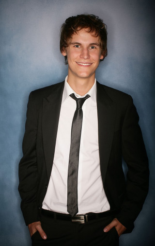 Young man suit tie posing - his hands in his pockets free wallpaper