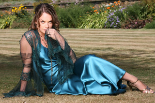 Woman blue dress sitting ground - the ground in a field of grass free wallpaper