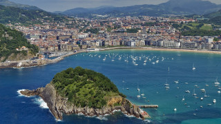 Small island city harbor sailboats - the water and a city in the background free wallpaper