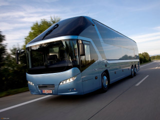 Large blue bus driving street - a forest of trees free wallpaper