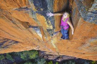 Woman climbing cliff arms out - a cliff free wallpaper for desktop