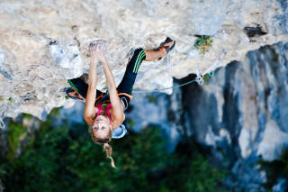 Woman climbing cliff rope helmet - hard focus free wallpaper