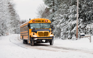 School bus snowy road woods - the background and a bench in the foreground free wallpaper