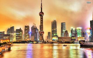 City skyline river boats cloudy - a colorful sky free wallpaper