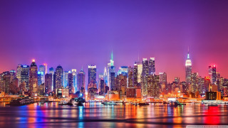 City skyline night tall buildings 35 - the water and a boat in the foreground free wallpaper