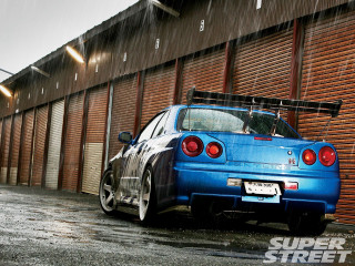 Blue car parked building surfboard - roof free wallpaper