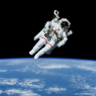 Astronaut floating above earth space - a stock photo free wallpaper