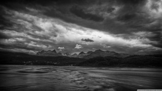 Black white mountain range clouds 2 - a body of water below free wallpaper