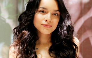 Woman long dark hair smile 2 - a wall in the background free wallpaper