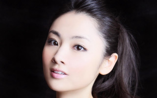 Woman ponytail smiling camera black 2 - a black background behind her free wallpaper