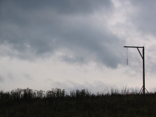 Tall pole wind indicator green - a lush green field under a cloudy sky free wallpaper