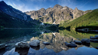 Mountain lake rocks trees blue - auseklis ozol free wallpaper