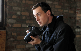 Man holding camera looking lens - eric dinyer free wallpaper