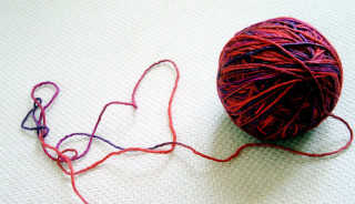 Yarn ball white surface red - triadic free wallpaper