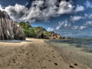 Beach rock formation boat water - a cloudy sky above free wallpaper