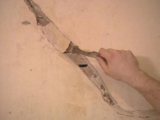 Man cutting hole wall plasterboard - a pair of scissors free wallpaper