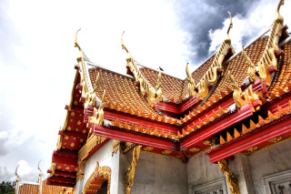 Building red roof gold decorations - a cloudy sky in the background free wallpaper