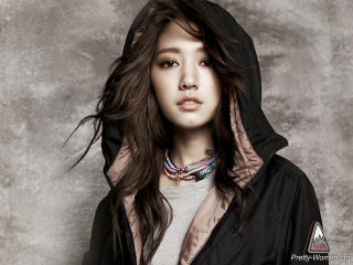 Woman hoodie pose gray background - a gray wall behind her free wallpaper