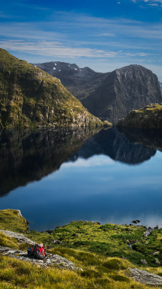 Lake mountains grass person sitting - free landscape wallpaper
