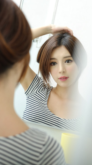 Woman looking mirror holding hair - a photorealistic painting free wallpaper