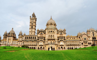 Large building clock tower grassy - a grassy field below free wallpaper