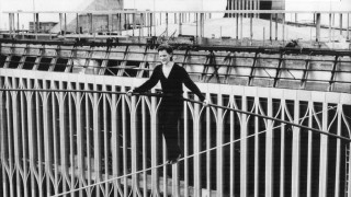 Woman standing railing building construction - symmetric free wallpaper
