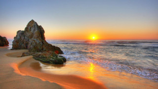 Sunset ocean rock formation beach - a rock formation in the foreground free wallpaper