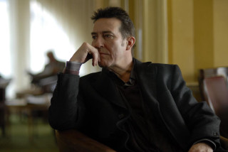 Man sitting chair hand chin 5 - david annand free wallpaper