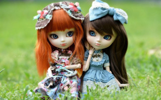 Two dolls sitting grass holding 3 - the others hand free wallpaper