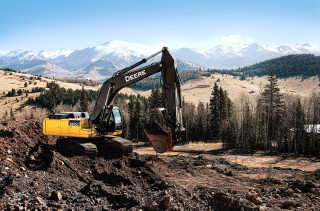 Large yellow excavator hillside mountains - a hill side free wallpaper