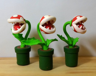 Three plastic plants mouths leaves - a white wall behind them free wallpaper